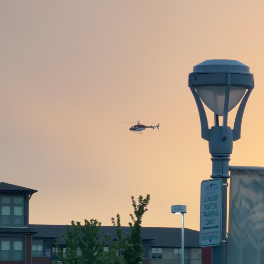 Bell 407 helicopter N407LP against a golden sunset sky over Broomfield Colorado